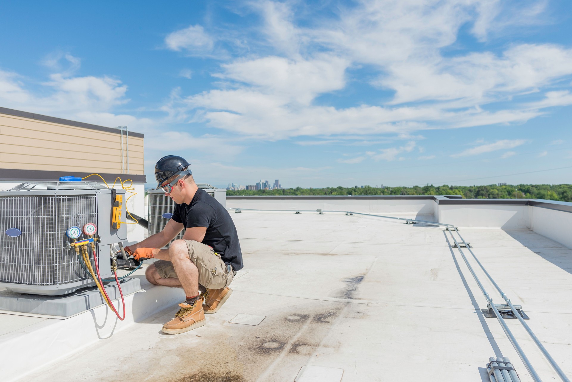 Hvac Tech checking Condenser with Blue Sky Background